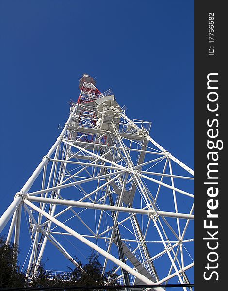 TV mast with microwave link and TV transmitter antennas over a blue sky. TV mast with microwave link and TV transmitter antennas over a blue sky