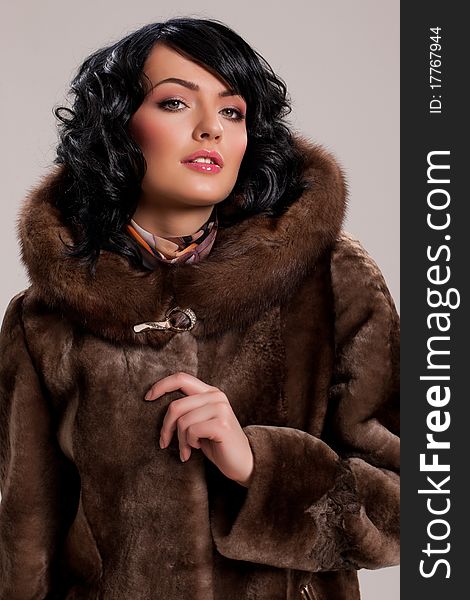 Young attractive woman in a fur coat on isolated background. Young attractive woman in a fur coat on isolated background