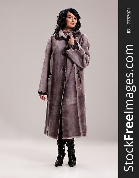 Young attractive woman in a fur coat on isolated background. Young attractive woman in a fur coat on isolated background