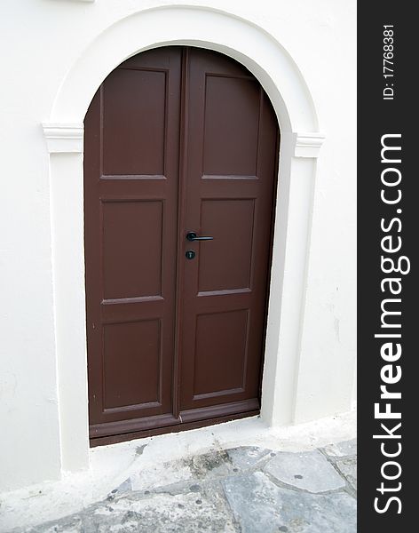 Brown door on the background of a stone wall