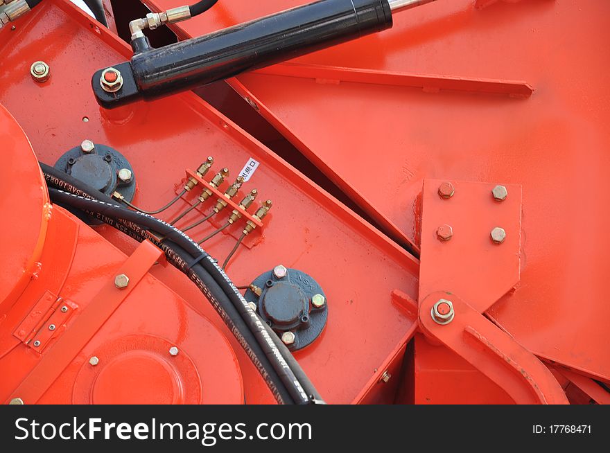 Part of a red colored reaping machine. Part of a red colored reaping machine.