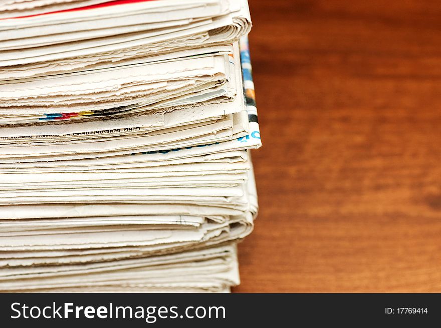 Heap of newspapers on a wooden table still life