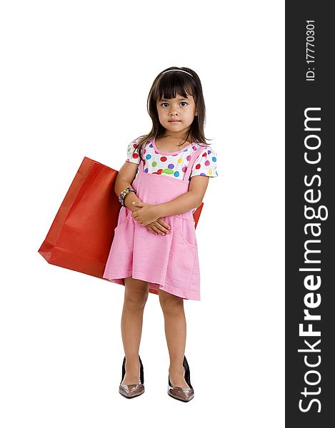 Cute little girl with shopping bag and oversized shoes, isolated on white background. Cute little girl with shopping bag and oversized shoes, isolated on white background