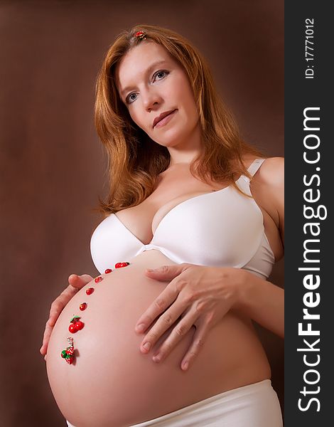 Pregnant woman to a dark brown background. Pregnant woman to a dark brown background