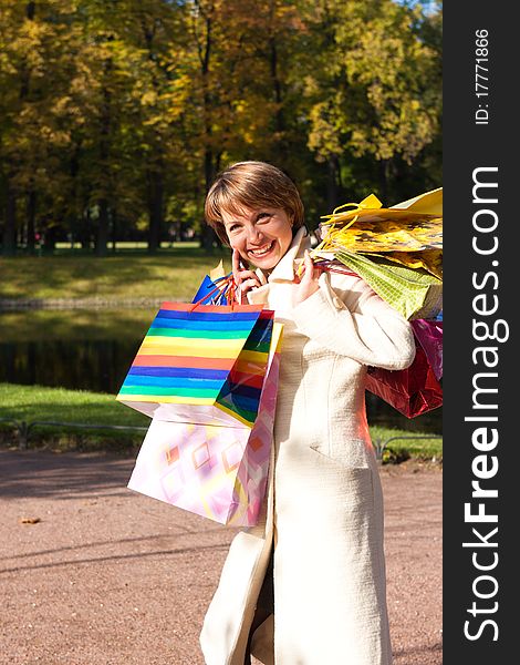 Charming young woman with purchases in an autumn park on nature