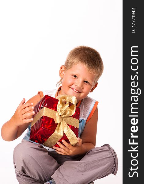 Merry little boy with a gift on white