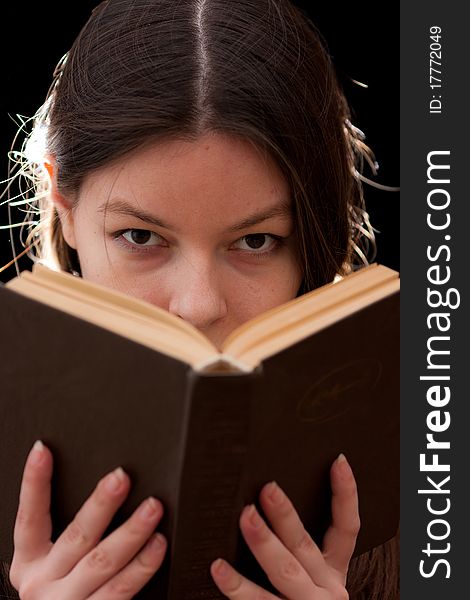 Charming young woman looking above a book. Charming young woman looking above a book