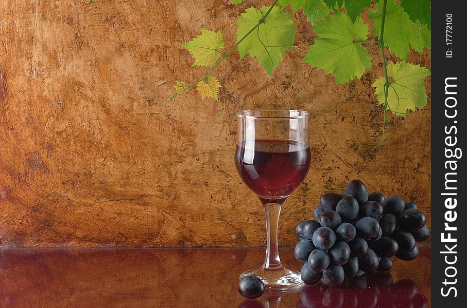 Glass of red wine and grape leaves