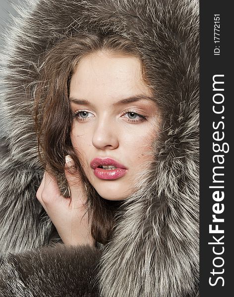 The young beautiful girl with chubby lips in a fur coat. The young beautiful girl with chubby lips in a fur coat