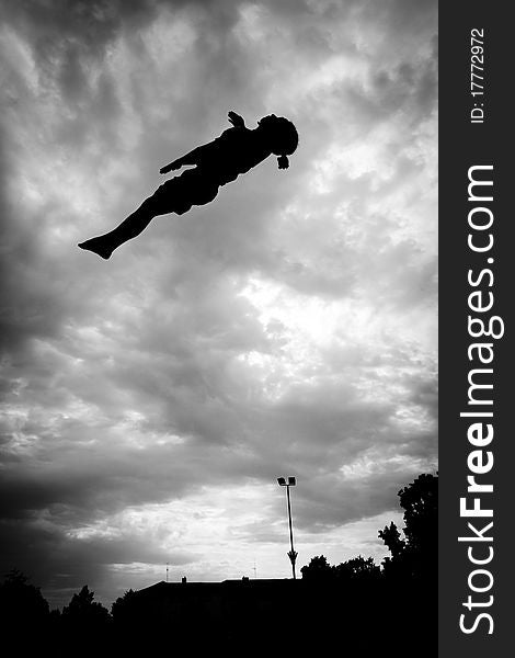 Silhouette Of Gymnast On Trampoline In Sky