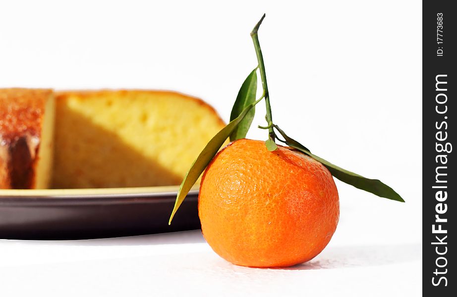 An orange fruit being an ingredient of the orange cake blurred in the background. An orange fruit being an ingredient of the orange cake blurred in the background