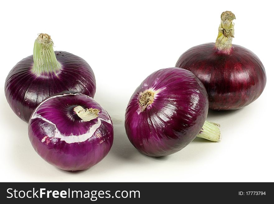 Four red onions with the outer peel removed, isolated on white.