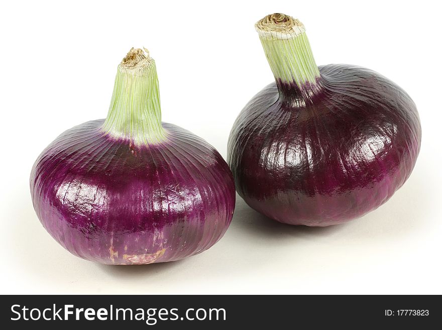 Two red onions with the outer peel removed, isolated on white.