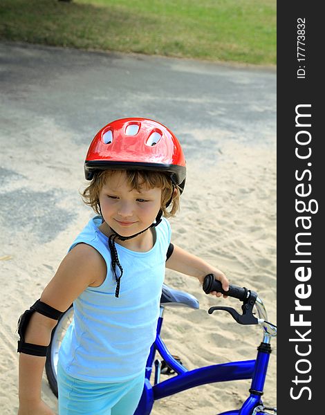 Girl in a red helmet, holding a bicycle. Girl in a red helmet, holding a bicycle