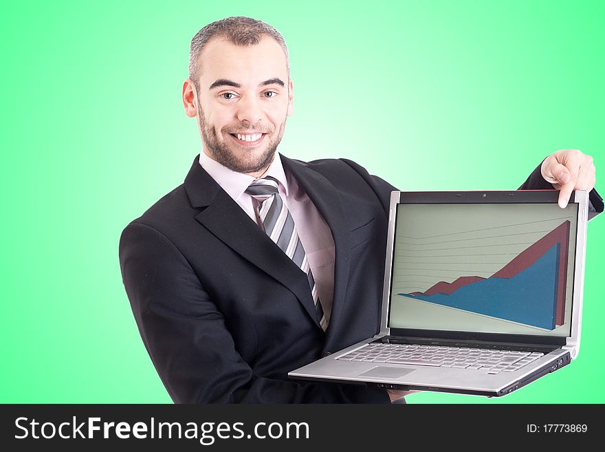 Business man pointing at a laptop with graph with green background