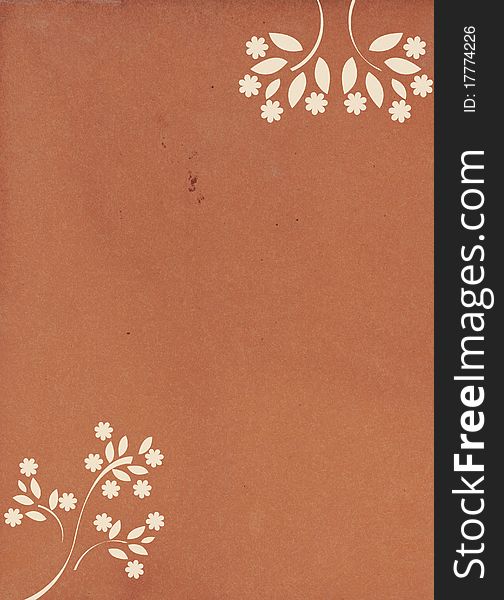 A brown parchment paper with white beige floral patterns in corners. A brown parchment paper with white beige floral patterns in corners