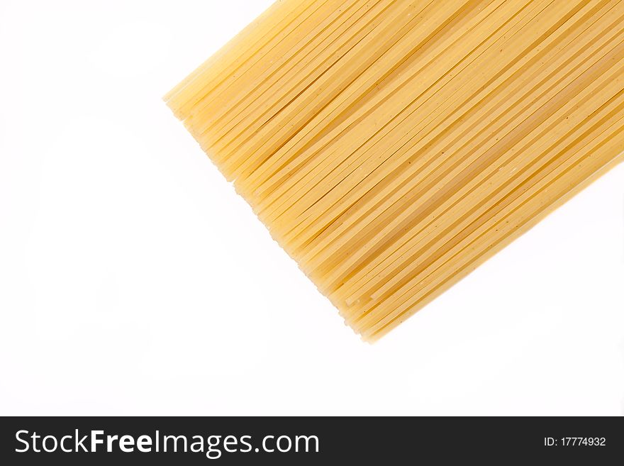 Spaghettis lie on a white background in the right part of a shot. Focus on the image middle