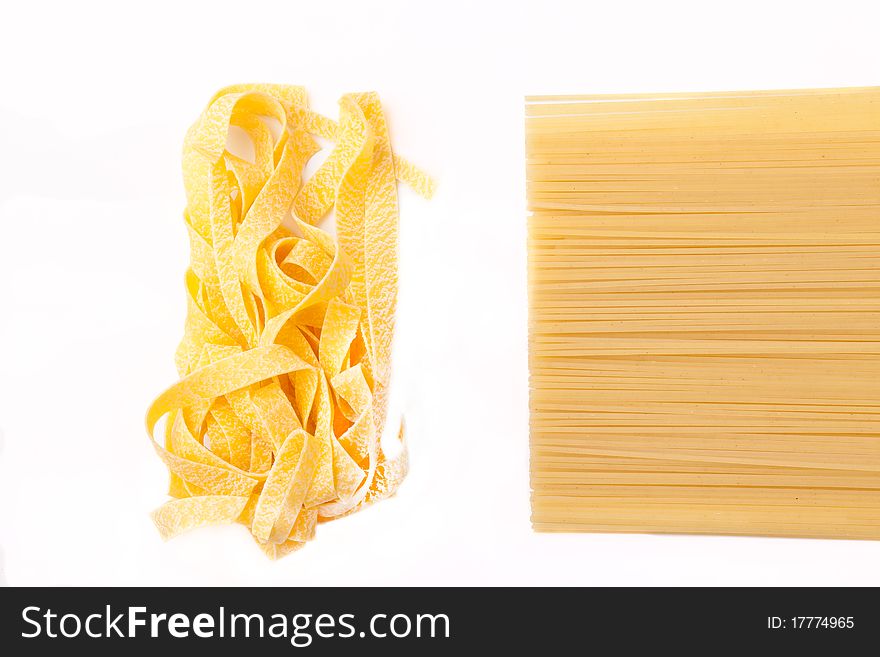 Two kinds of a spaghetti lie on a white background. Focus on the shot middle.