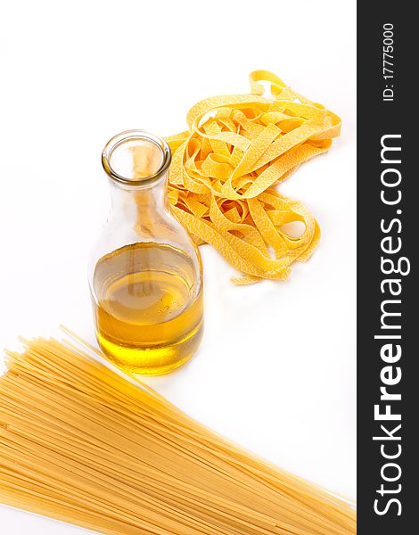 Two kinds of a spaghetti and olive oil bottle on a white background. Focus in the shot center. The top view.