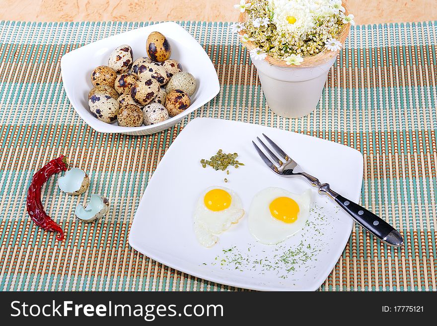 Quail eggs, as eggs, fried, on a white plate.