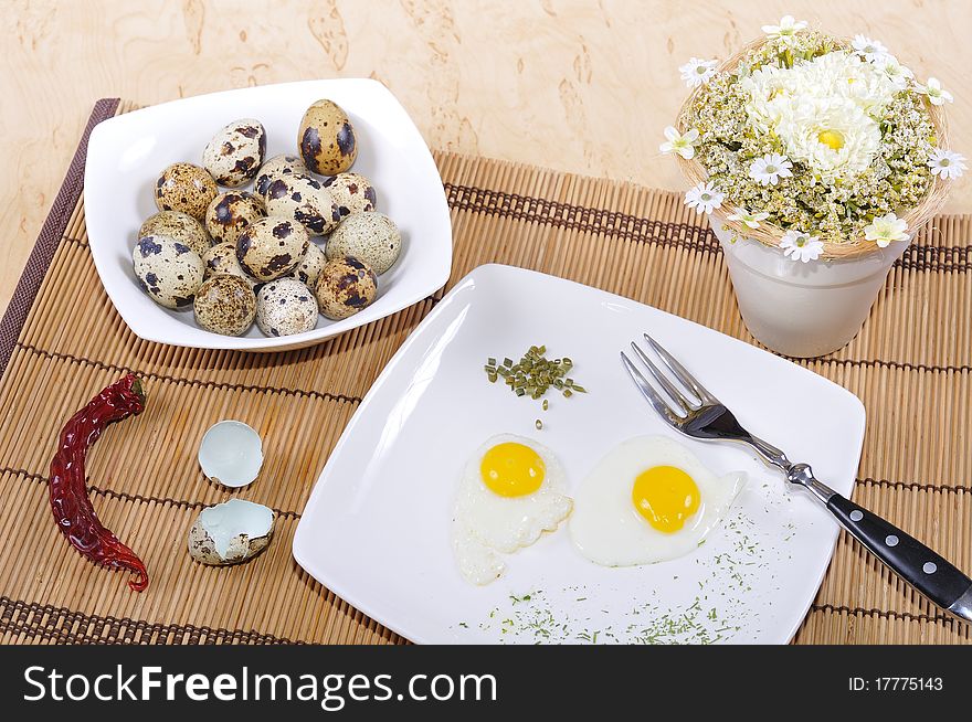 Quail eggs, as eggs, fried, on a white plate.