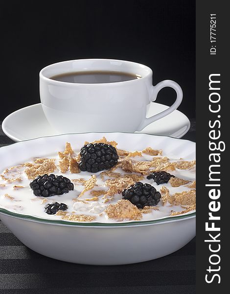 Light morning meal from cereals with berries of a blackberry and milk, in a coffee cup. Light morning meal from cereals with berries of a blackberry and milk, in a coffee cup.