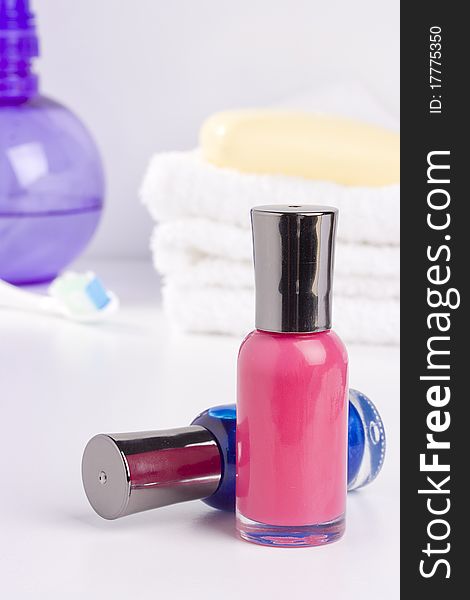 Two nail polish bottles placed in front of bathroom accessories.