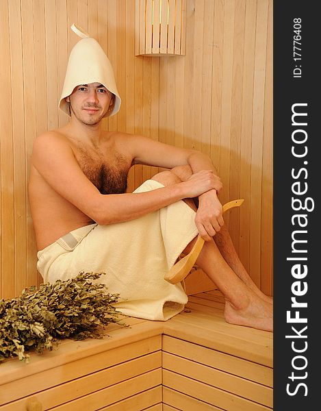 Young Man Relaxing In A Russian Wooden Sauna