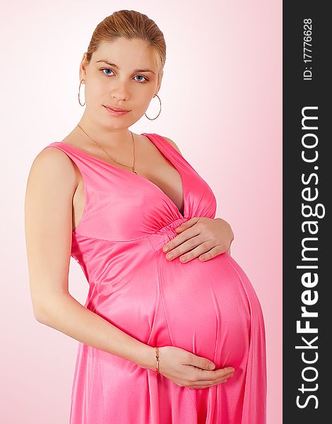 Portrait of a beautiful pregnant woman over pink background