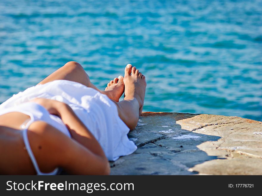 Girl in white dress is resting next to the sea. Girl in white dress is resting next to the sea