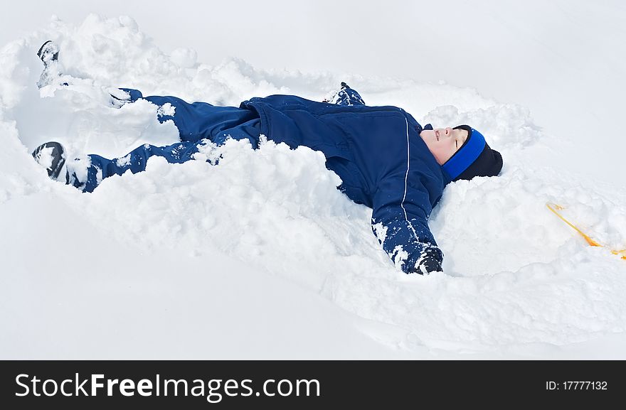 Little boy laying in the snow