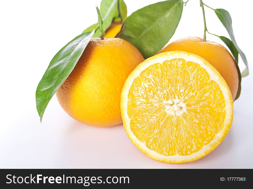 Ripe oranges with leaves, isolated on a white.