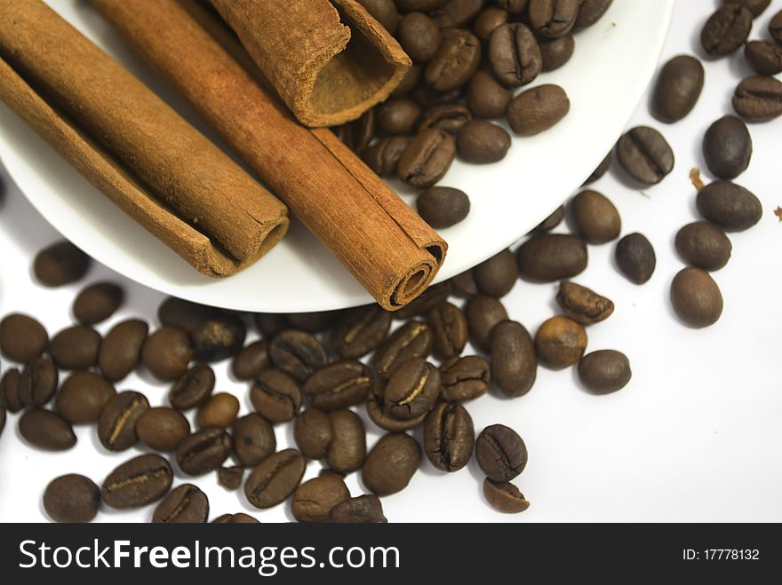 Coffee beans and cinnamon sticks on white. Coffee beans and cinnamon sticks on white