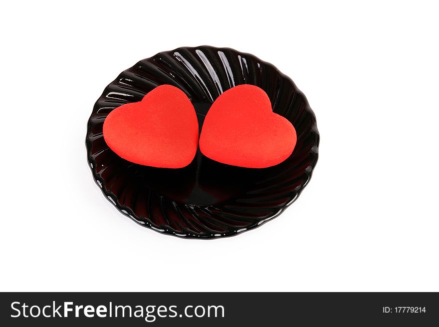 Two red hearts in a plate. Isolated on the white