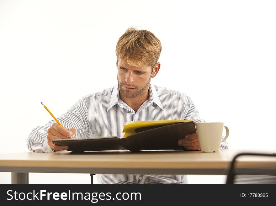 Businessman reading and writing at desk. Businessman reading and writing at desk