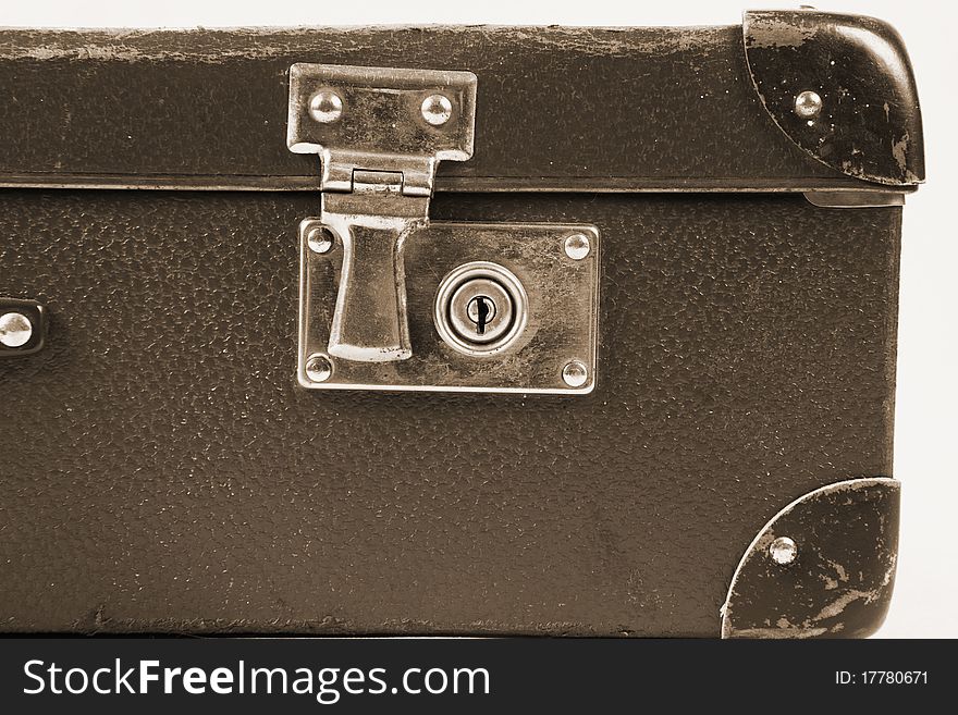 Vintage suitcase with a lock in sepia in close up