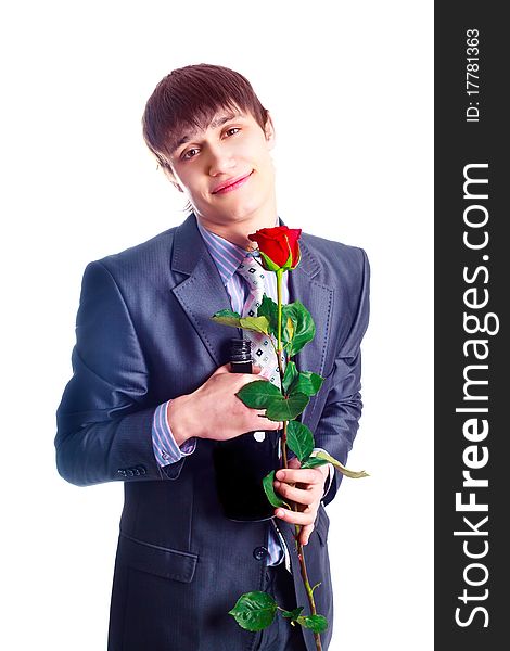 Handsome young man with a red rose and a bottle of brandy. Handsome young man with a red rose and a bottle of brandy