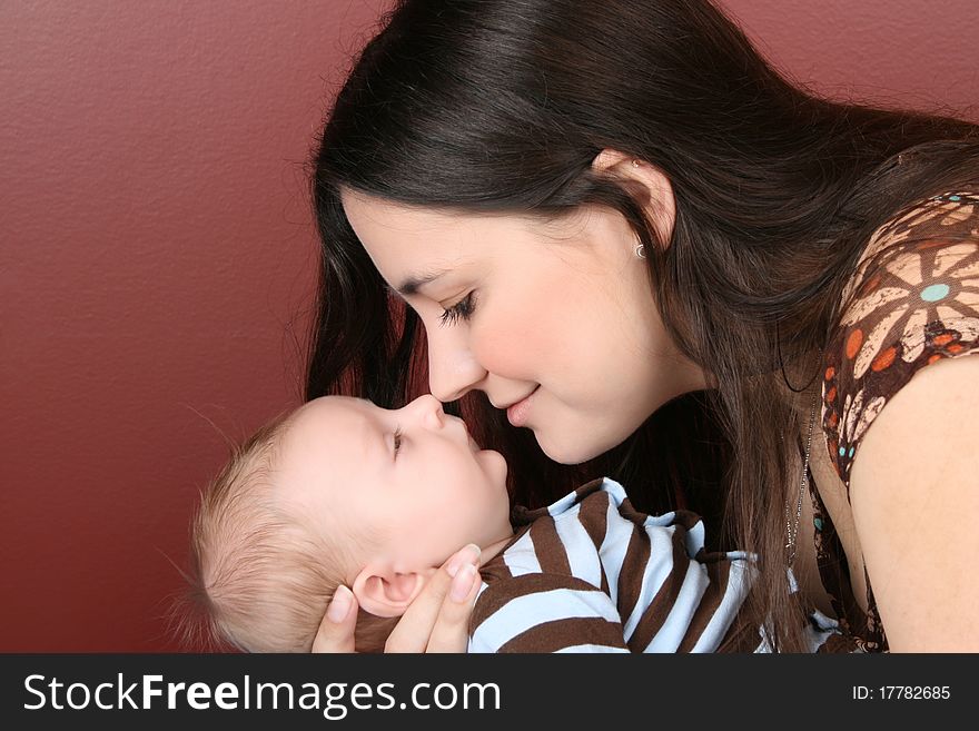 Brunette mother holding her newborn baby boy. Brunette mother holding her newborn baby boy