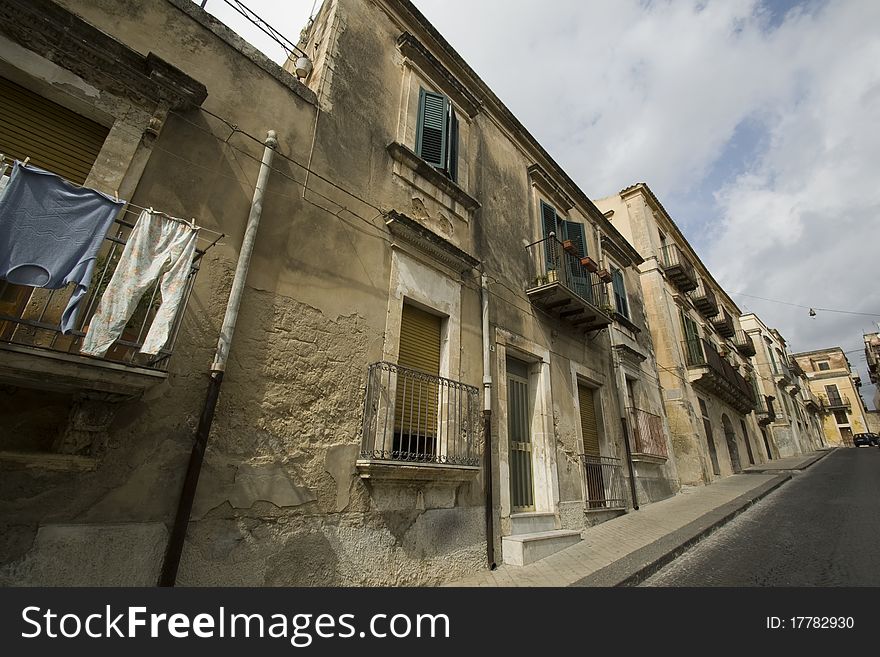 Tipical Street in Sicily (italy), ancient building and clothes on balcony