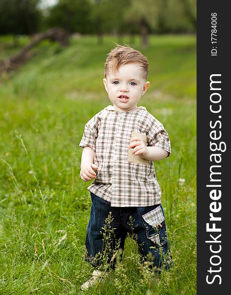 1 year old caucasian boy doing his first steps in the park. 1 year old caucasian boy doing his first steps in the park