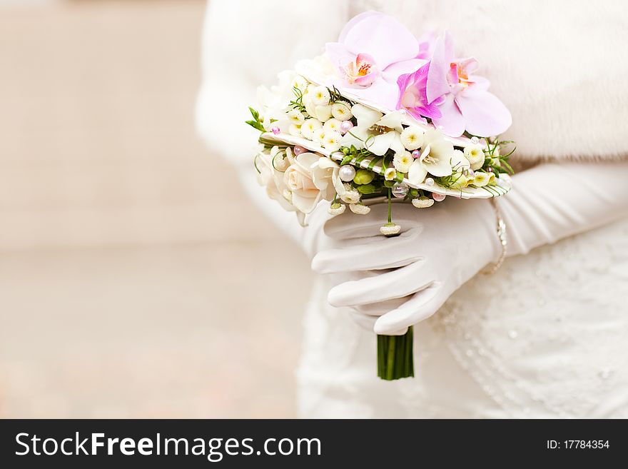 Hands of bride holding beautiful boquet with violet orchids. Hands of bride holding beautiful boquet with violet orchids