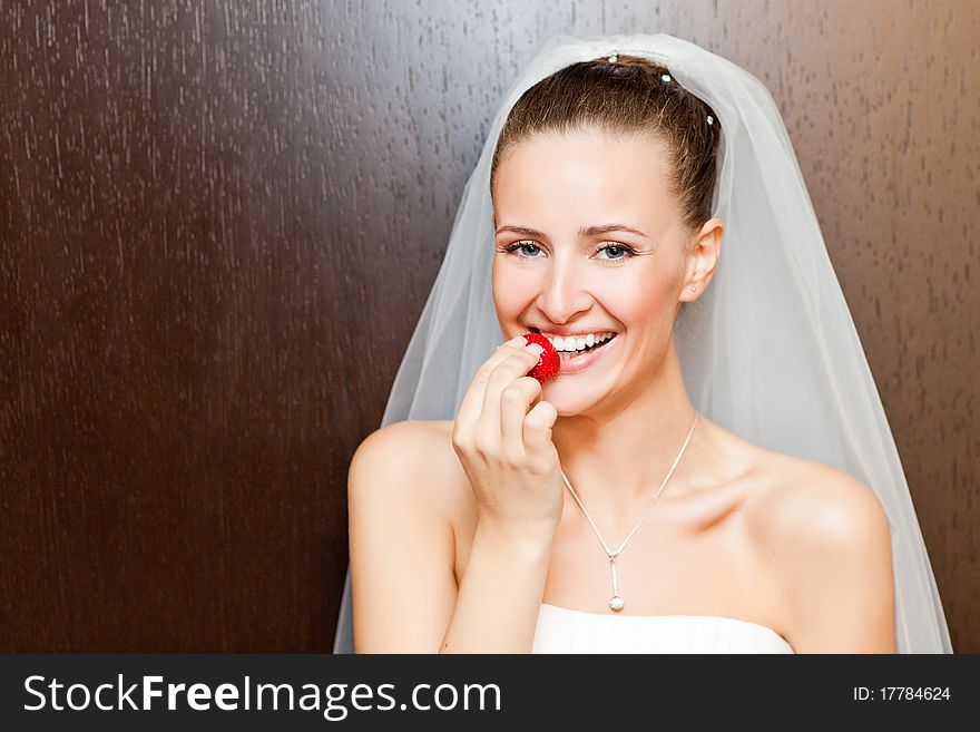 Attractive caucasian bride eating strawberry and looking at camera. Attractive caucasian bride eating strawberry and looking at camera