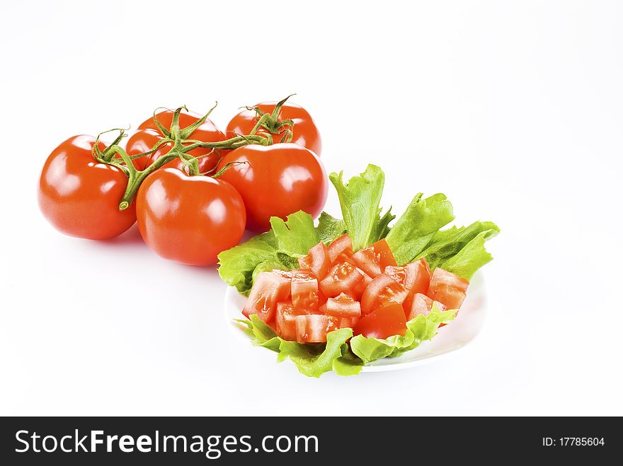 Bunch of tomatoes with one diced on lettuce