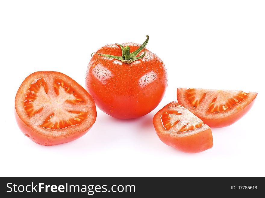 Fresh tomato with one half and two quarters over white. Fresh tomato with one half and two quarters over white