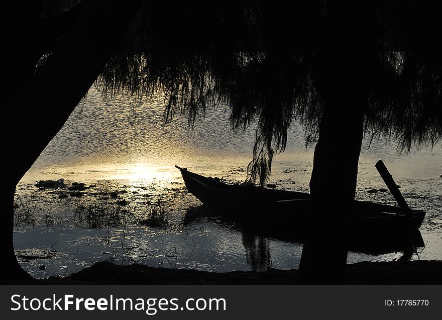 Silhouette of boat on a lake at evening glow
