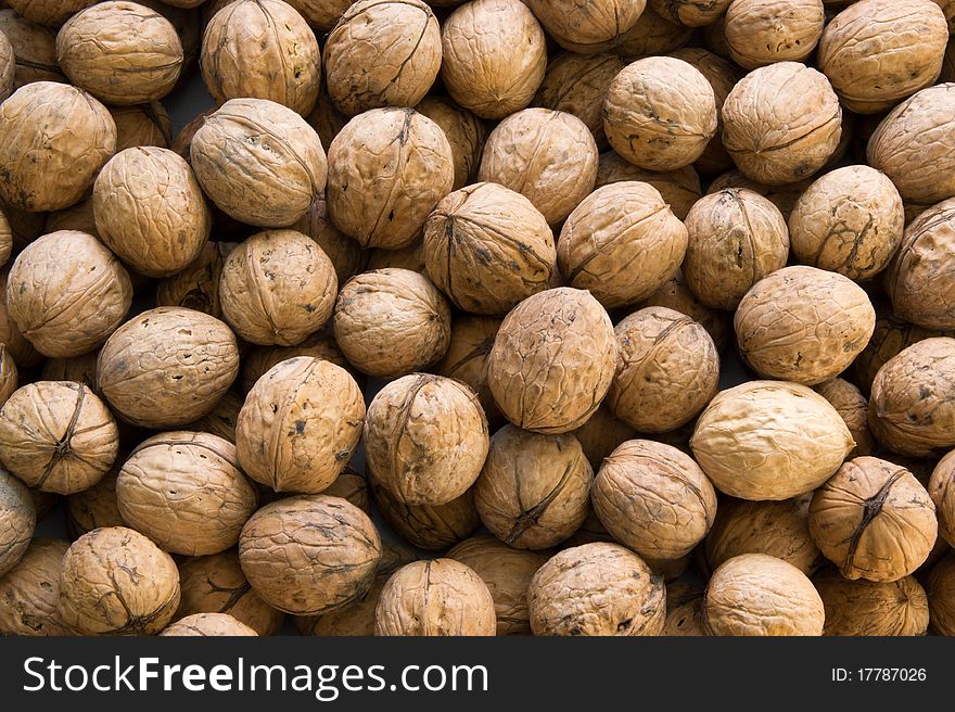 Closeup of brown raw walnuts background