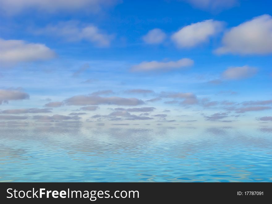 A lot of fluffy clouds on blue sky over big water