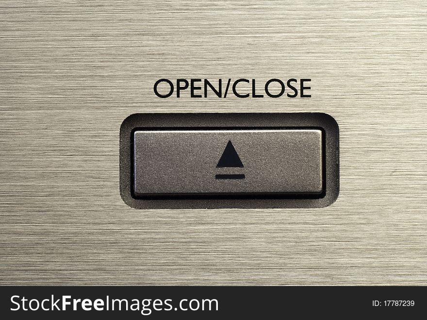 Close up of Open/ Close button on brushed metal background