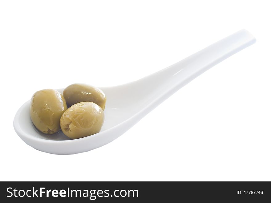 Olives on white ceramic spoon
