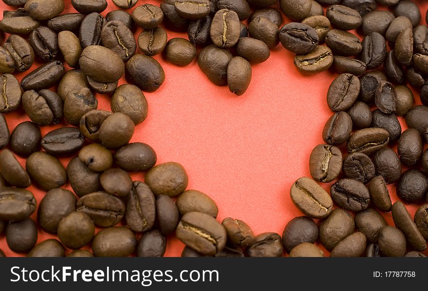 Creative photo of coffee beans making up form of heart of red color